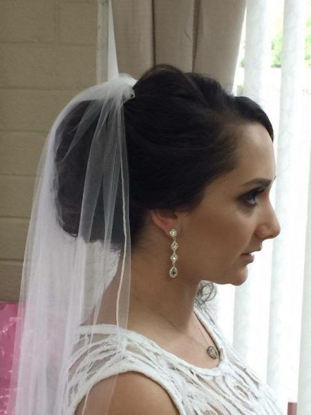 Reflections Hair Salon specializes in making brides look glamorous on their special day. This updo is styled around the bride's long veil for her special day!