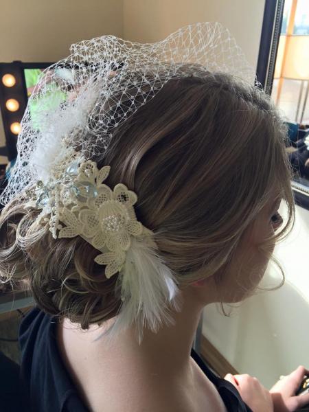 This bridal updo is styled around the bride's short, exquisite veil for a unique and memorable hair style for her wedding day. 